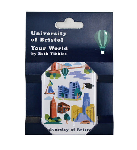 A magnet within its packaging. The magnet has pictures of Clifton Suspension Bridge, Senate House, Brandon Tower and Park Street.