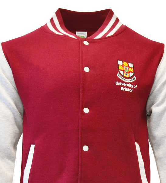 A close up of the top half of a baseball jacket with a burgundy torso and white sleeves. There is burgundy and white stripes around the collar, white buttons down the front and the crest of the University of Bristol over the left chest.